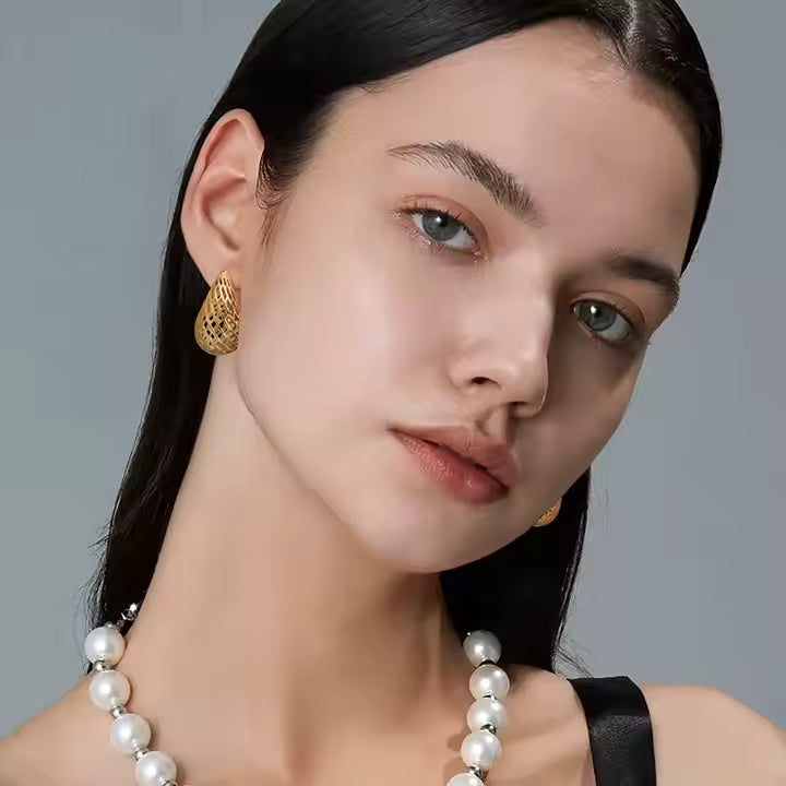 18K gold-plated lattice teardrop stud earrings with sculpted openwork design on studio background