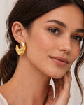 Model wearing molten sculpt hoop earrings, 18k gold-plated chunky hoops for women
