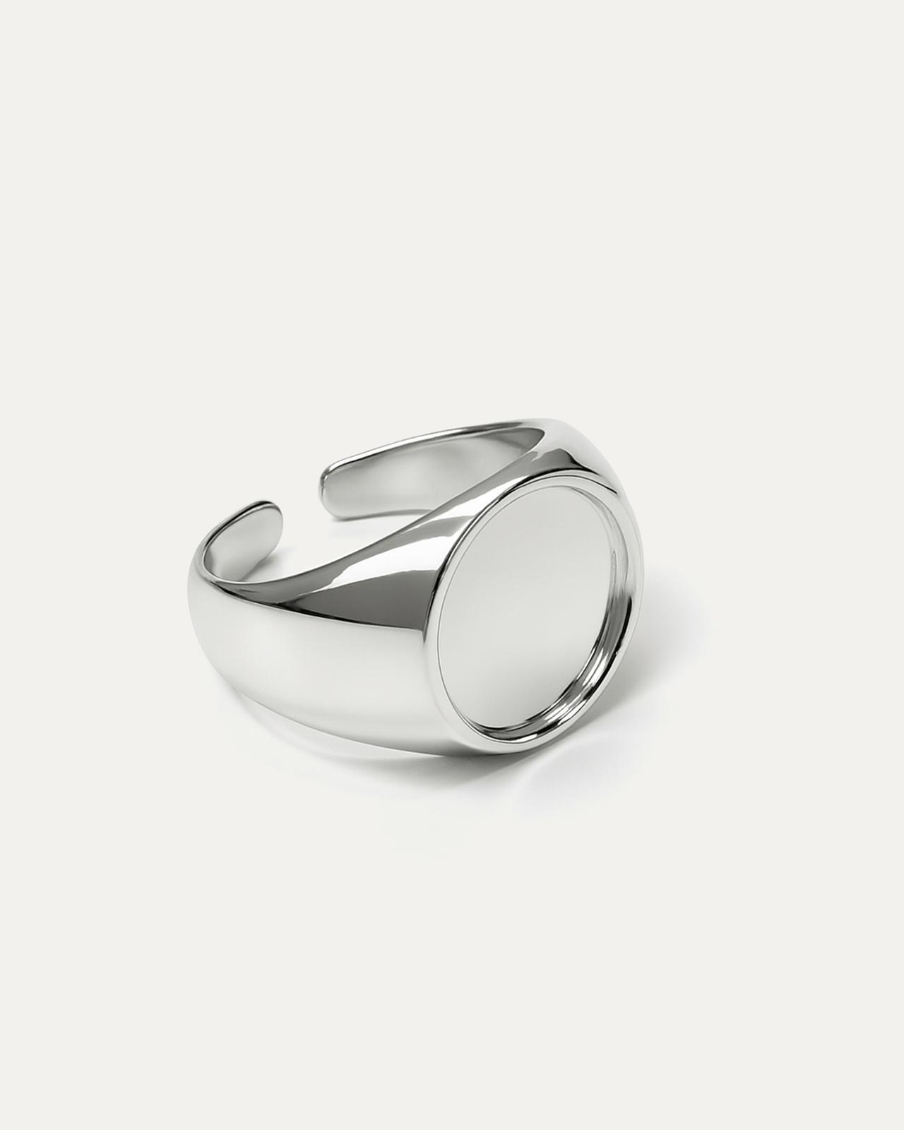 A chunky, open-cuff silver signet ring with a high-polish finish. The ring features a thick, adjustable band and a large, rou