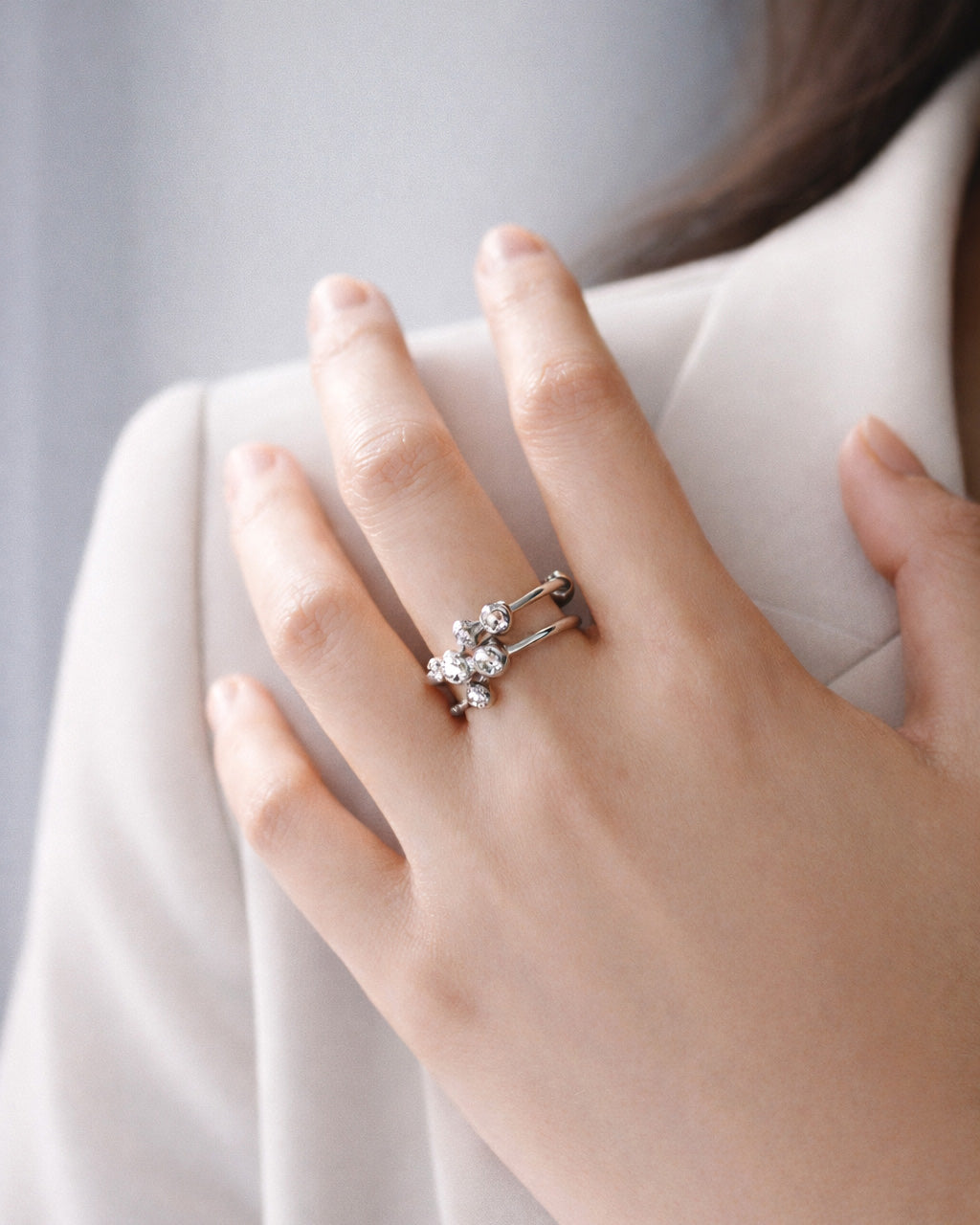 Silver-plated orbit stack ring on model hand, minimalist layered statement jewelry