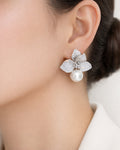 Silver floral pearl drop earrings on ear with cubic zirconia accents for women
