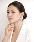 Model wearing silver floral pearl drop earrings with cubic zirconia accents style