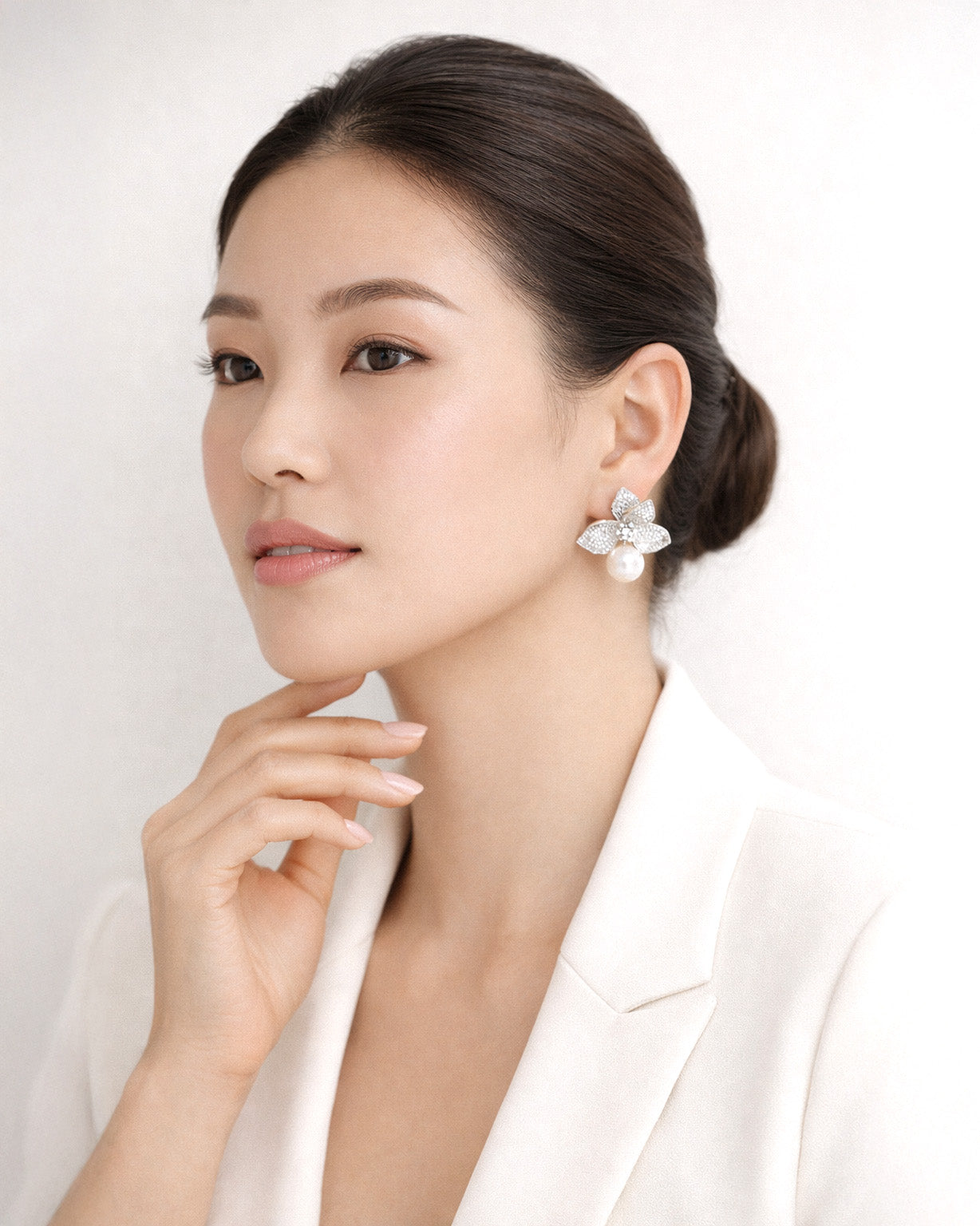 Model wearing silver floral pearl drop earrings with cubic zirconia accents style