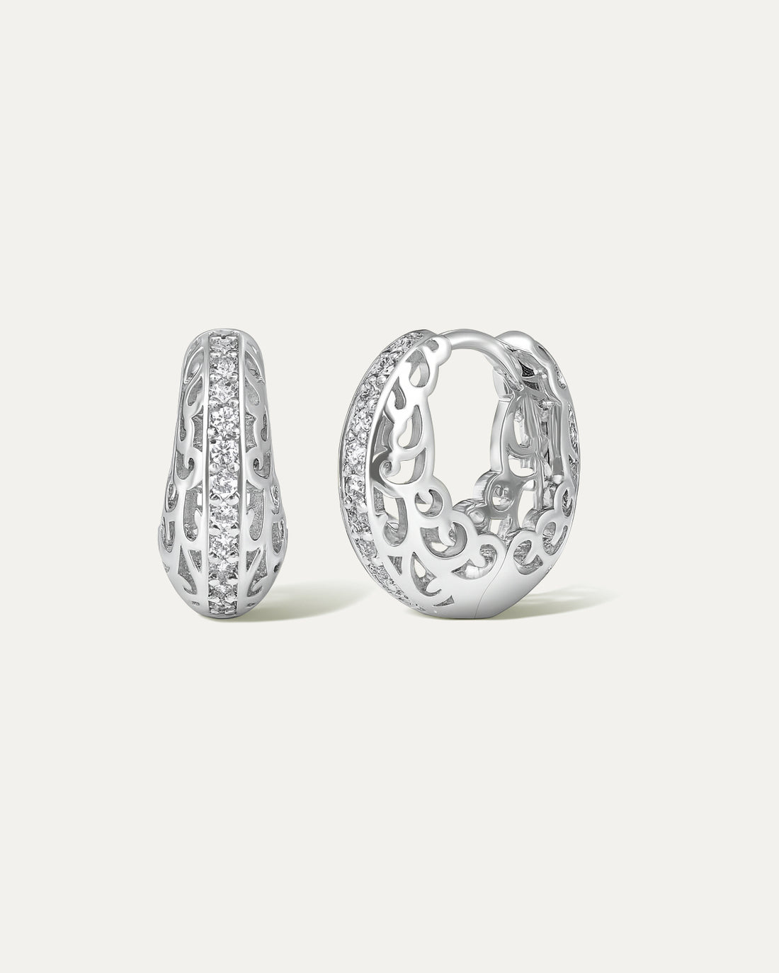 Pair of silver hoop earrings with intricate designs on a light gray background