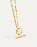 Gold necklace with a unique clasp design on a light gray background