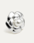 A close-up studio shot of a single silver-tone flower stud earring on a plain white or light beige background. The earring fe