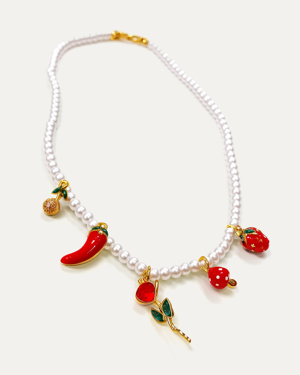Pearl necklace with colorful fruit charms on a white background
