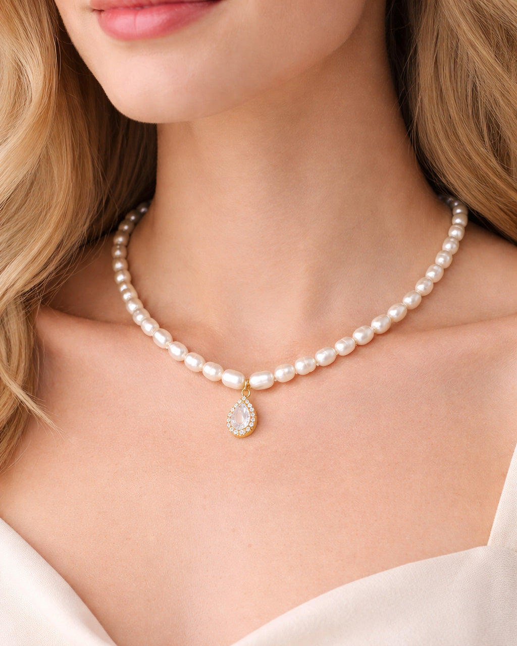 Pearl choker necklace with crystal teardrop pendant worn by model, 18k gold plated