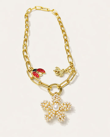 18K gold-plated charm necklace with pearl flower pendant, featuring a bold chain design and decorative charms by Jadejuri