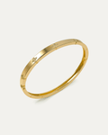 Angled view of a polished gold petite daisy bangle bracelet on a white background, showcasing the slim profile and multiple s