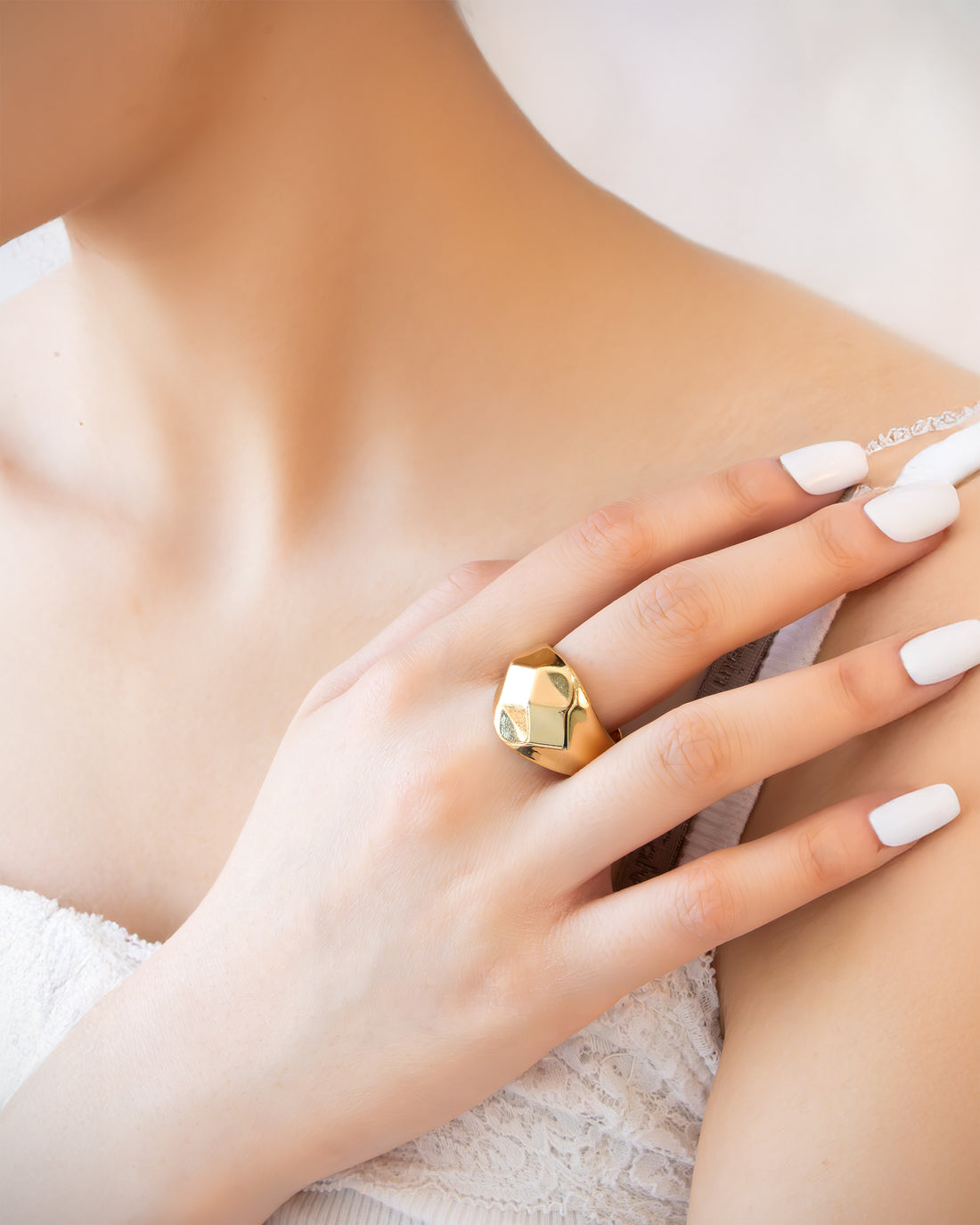 Minimalist gold signet ring with smooth pyramid relief on a polished band