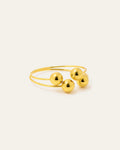 Gold ring with three spherical beads on a white background