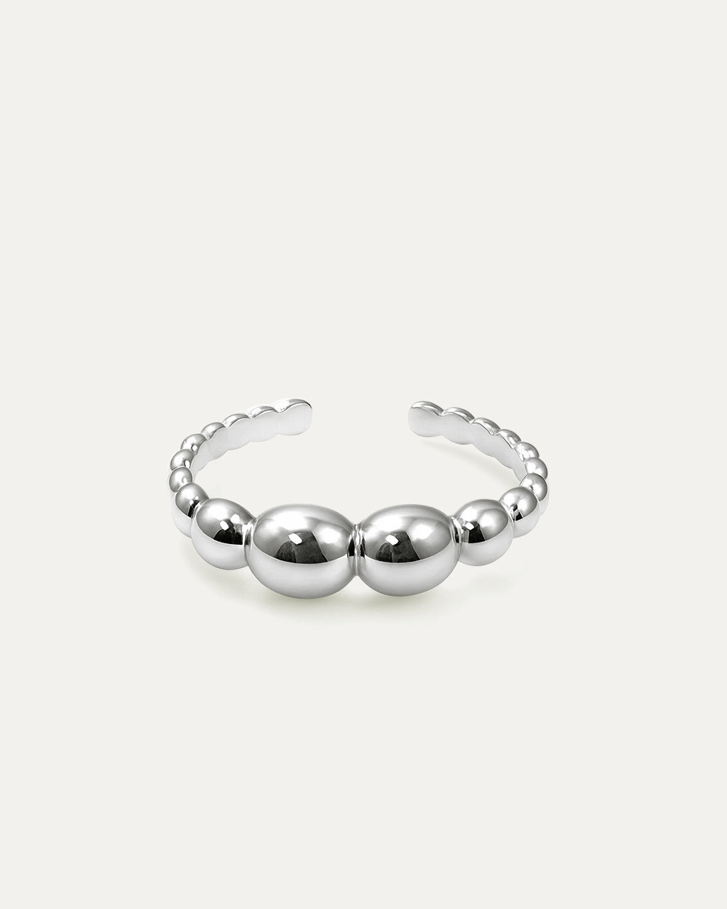 A close-up studio shot of a silver-tone cuff ring on a plain white or light beige background. The ring has an adjustable, ope