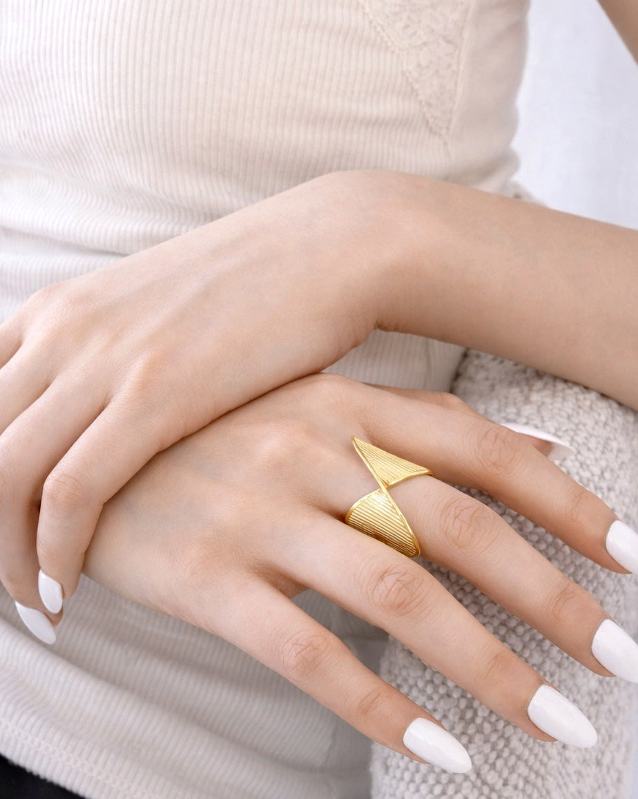 18K gold-plated ripple curve statement ring on model hand, modern sculptural