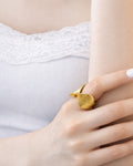 18K gold-plated ripple curve statement ring worn on model hand modern sculptural
