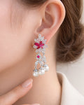 Rose fleur pearl drop earrings on ear with pink cubic zirconia silver plated