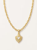 Gold necklace with a heart-shaped pendant on a light gray background