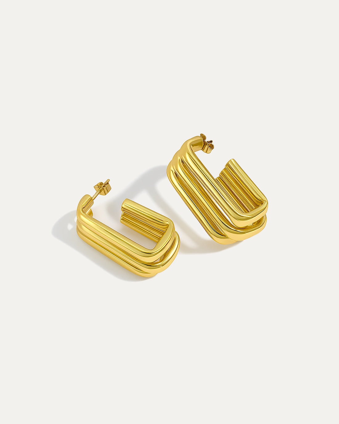 Gold sculpted column hoops with bold geometric triple-bar design, modern fashion earrings for statement wear.
