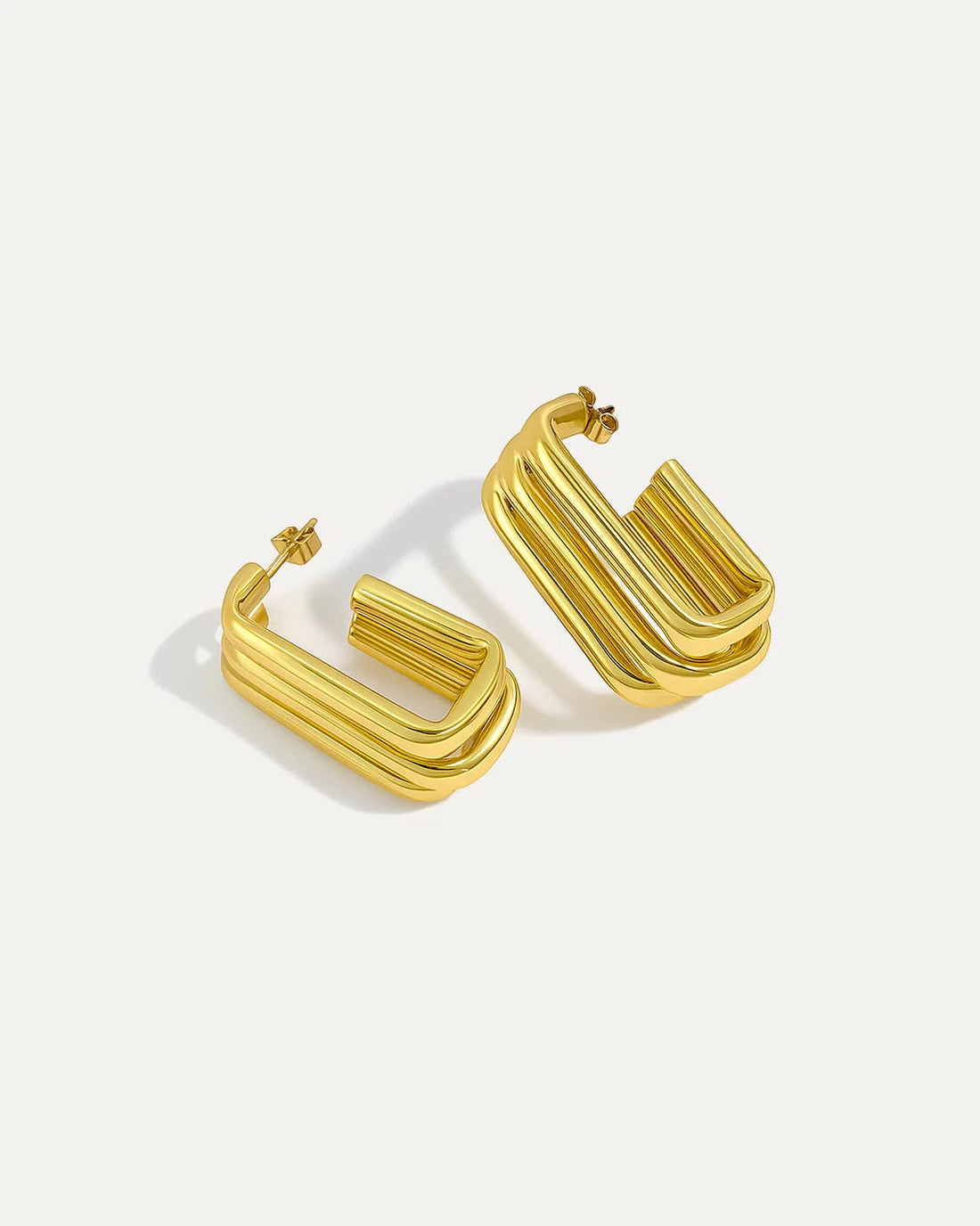 Gold sculpted column hoops with bold geometric triple-bar design, modern fashion earrings for statement wear.