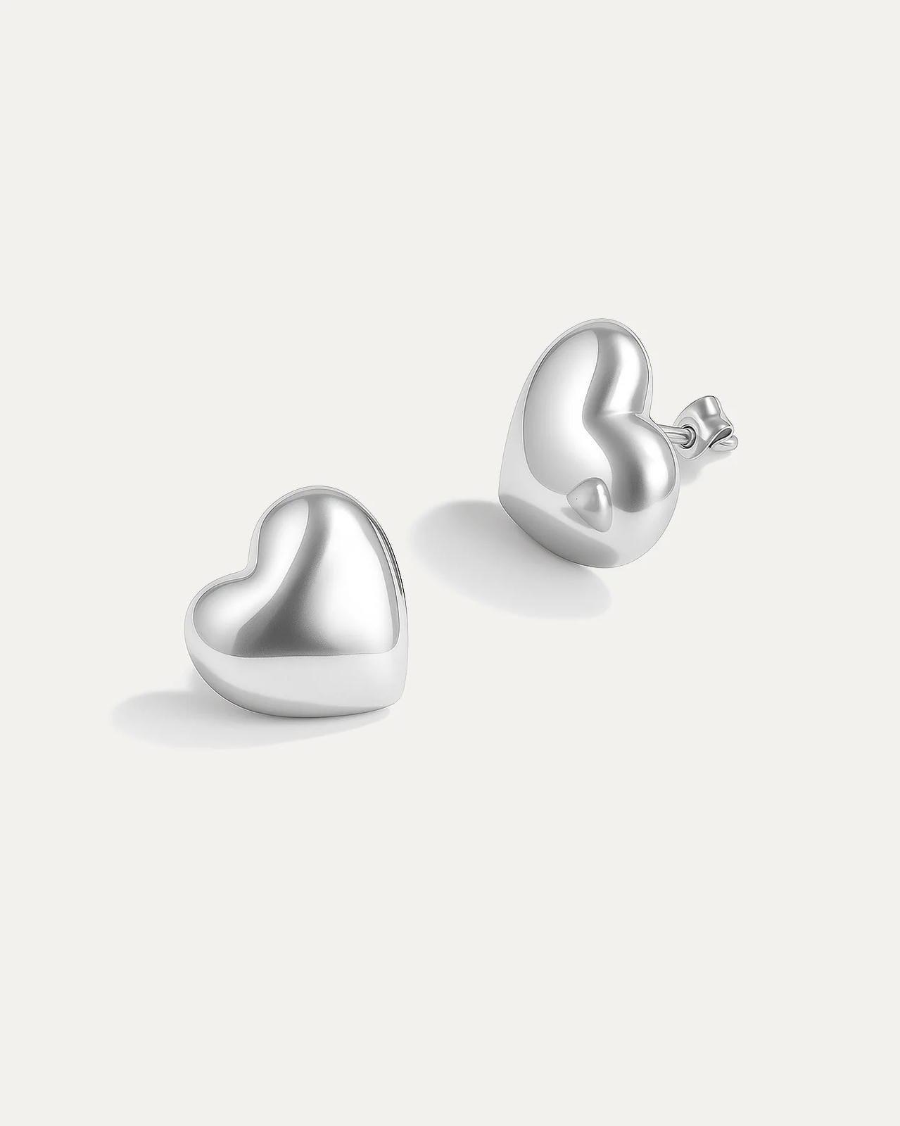 Silver heart-shaped earrings on a white background