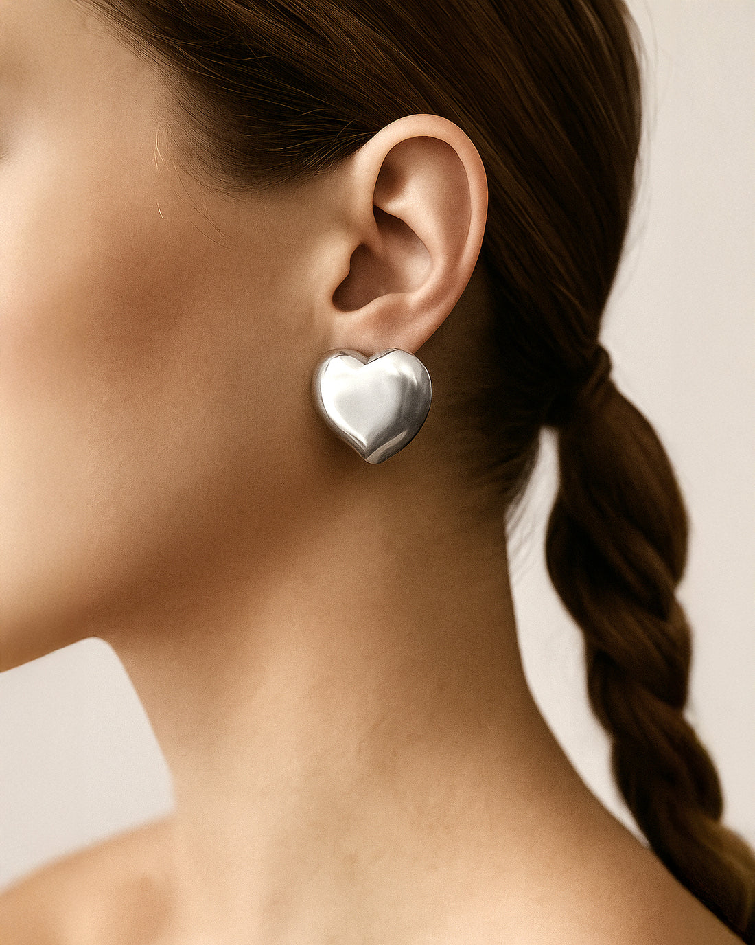Sterling silver sculpted heart stud earrings with high-polish finish.