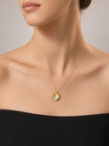 Gold necklace with a pendant on a model against a neutral background