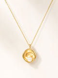 Gold necklace with a pendant featuring a pearl on a light beige background