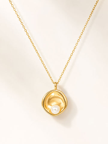 Gold necklace with a pendant featuring a pearl on a light beige background