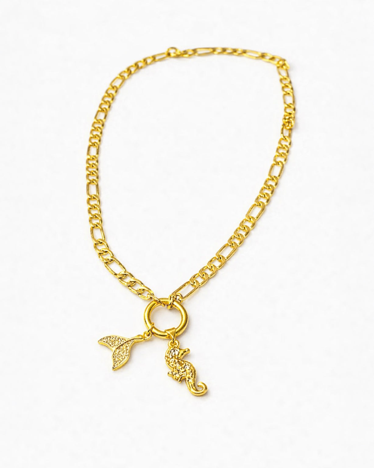 Gold chain necklace with a mermaid tail and key pendant on a white background