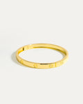 Gold bracelet on a light gray background