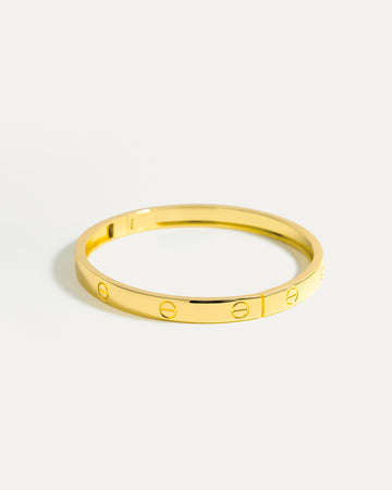 Gold bracelet on a light gray background