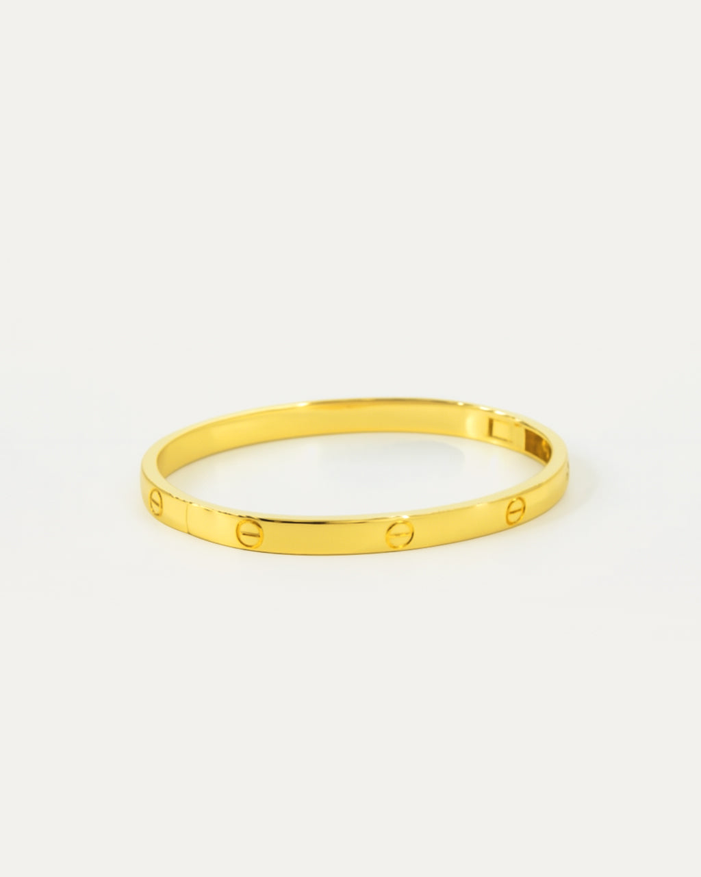 Gold bracelet on a light gray background
