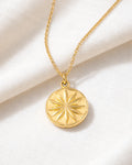 18K gold-plated star coin pendant necklace on fabric, minimalist jewelry close-up