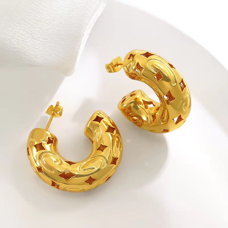 Gold-plated chunky hoop earrings with geometric star cutout pattern and curved design