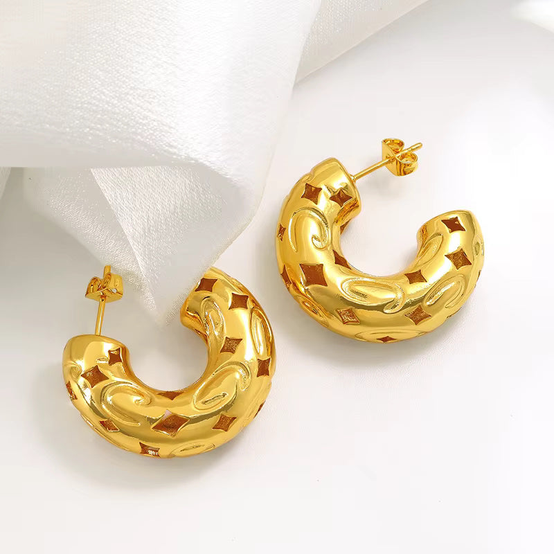 Gold-plated chunky hoop earrings with geometric star cutout pattern and curved design