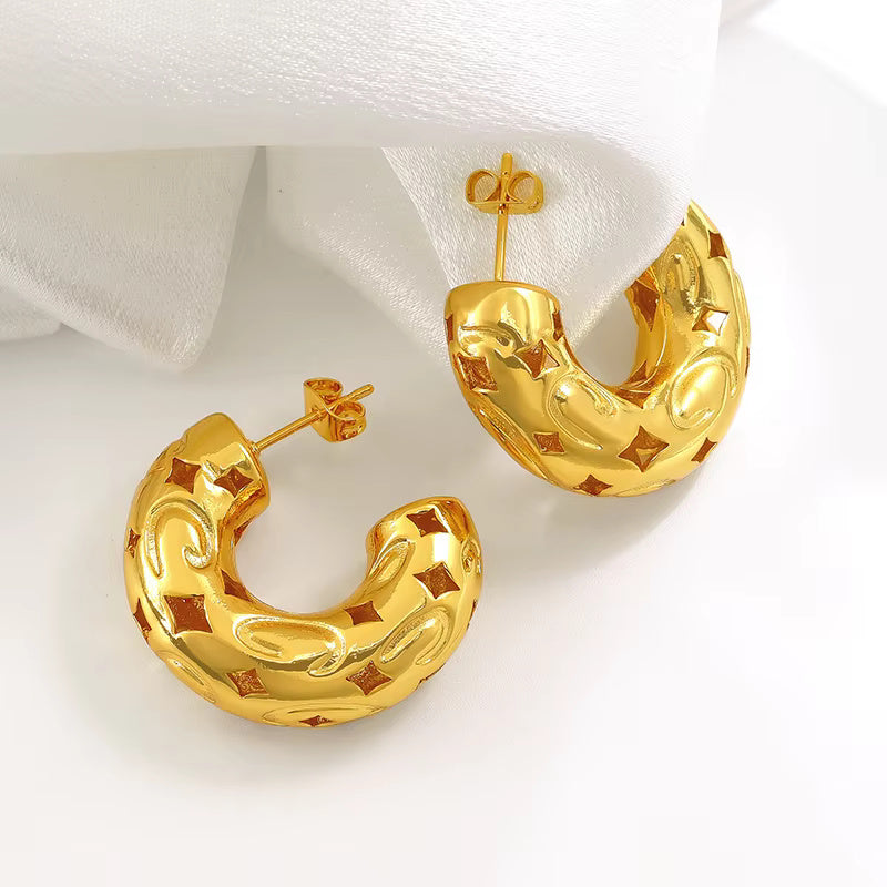 Gold-plated chunky hoop earrings with geometric star cutout pattern and curved design