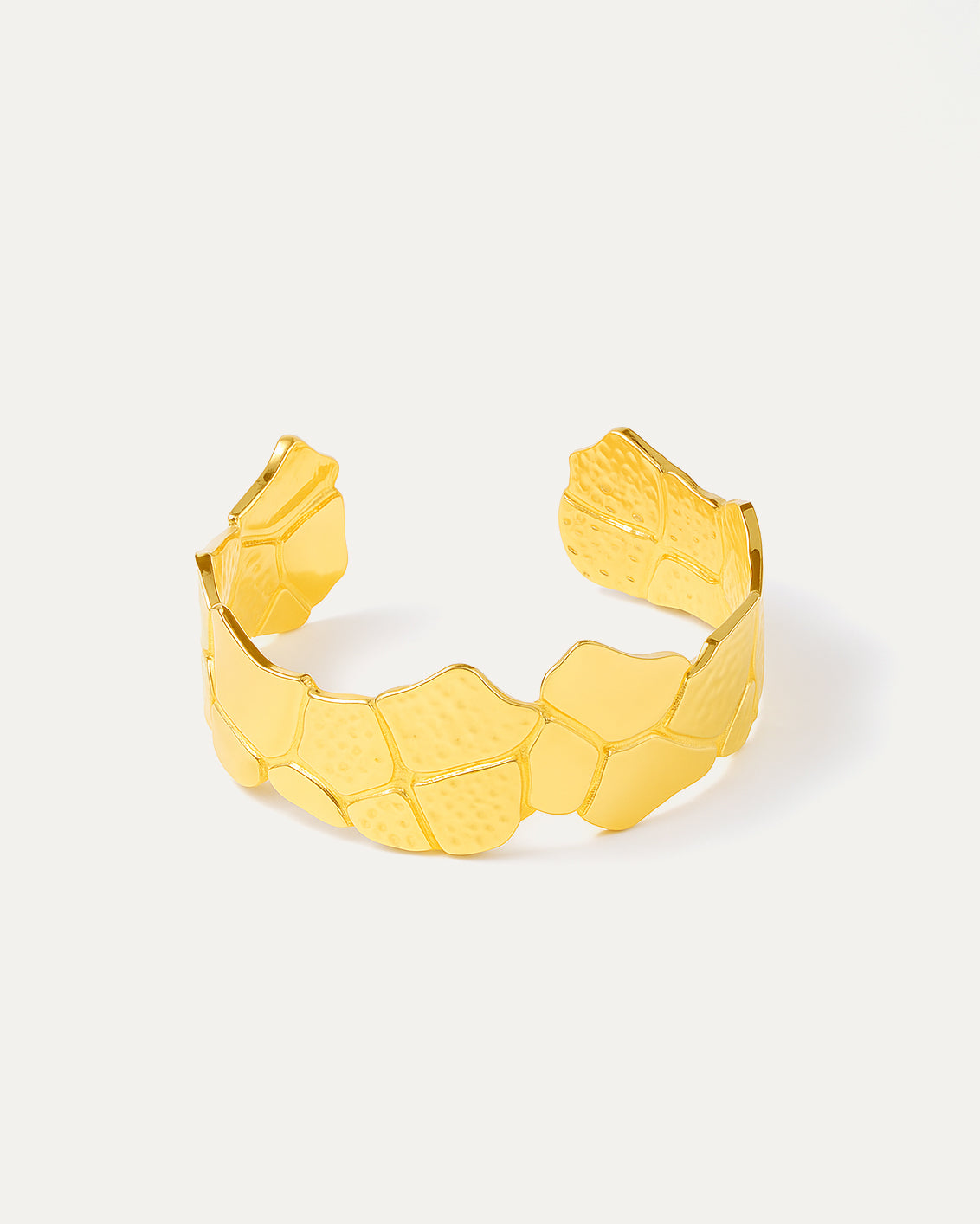 Gold bracelet with a textured pattern on a white background