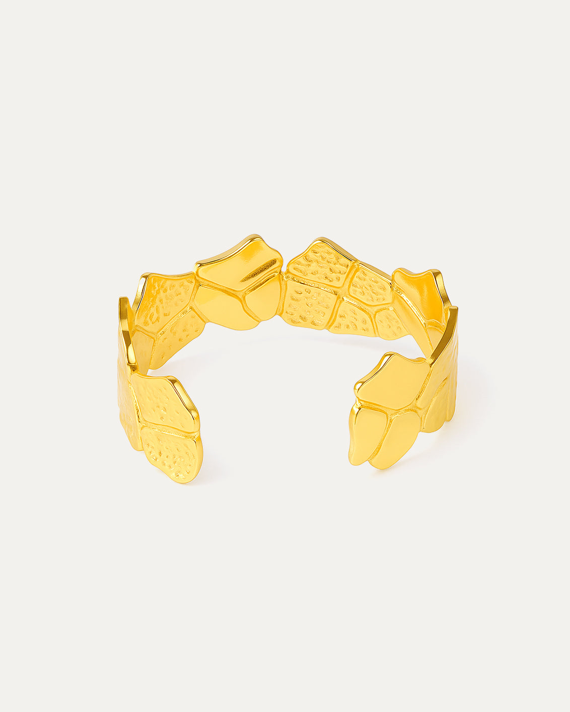 Gold bracelet with geometric design on a light gray background