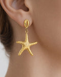 Gold starfish drop earring in 18K gold-plated finish worn on model close-up