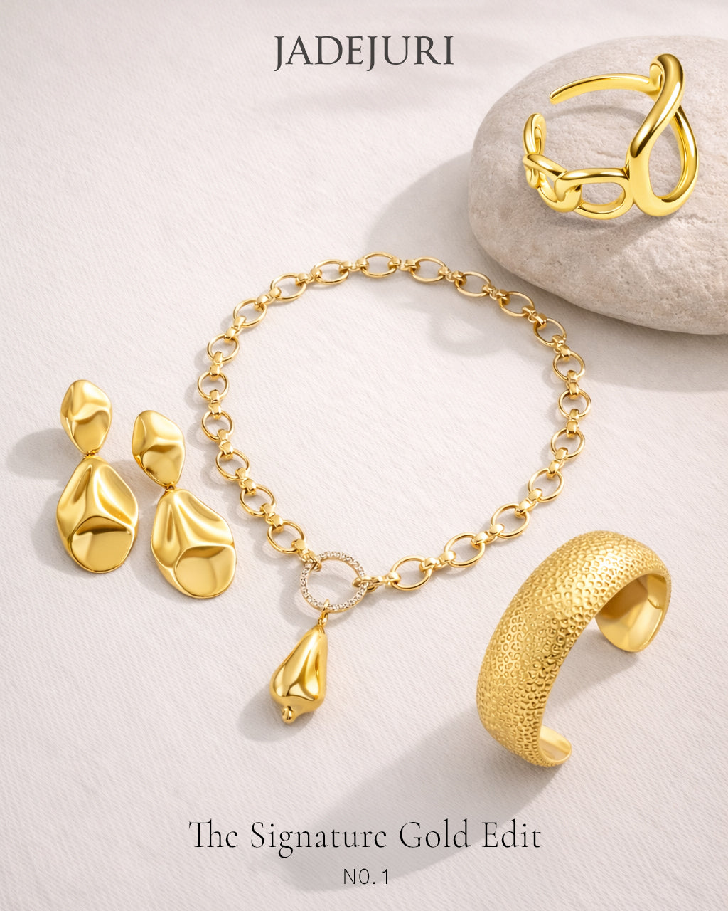 Gold jewelry set including earrings, bracelet, and ring on a light background with 'JADEJURI' branding.