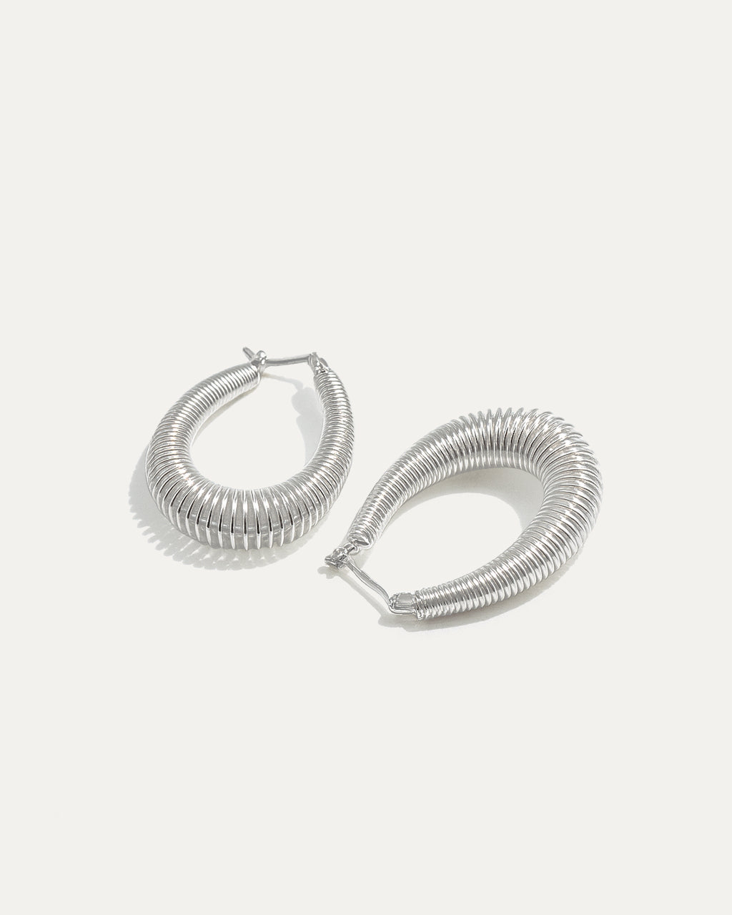 Pair of silver hoop earrings on a white background