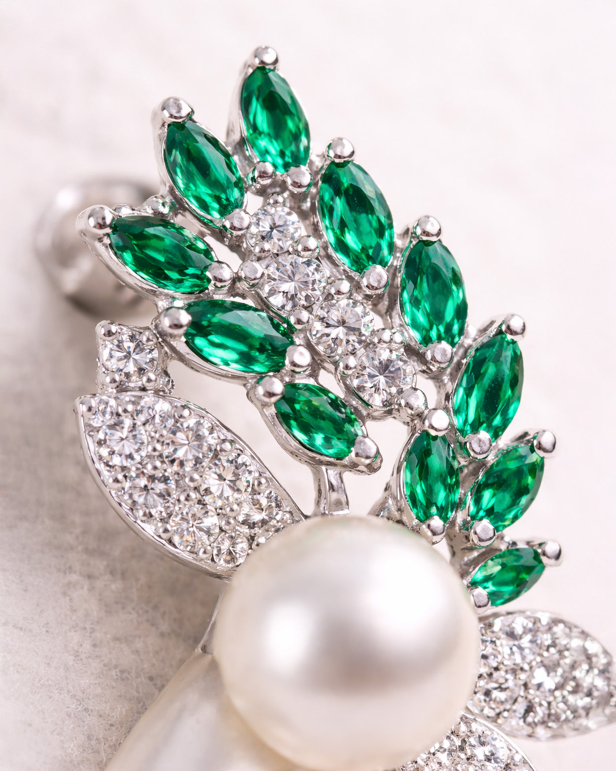 Green zircon pearl leaf drop earrings close up in silver plated setting detail