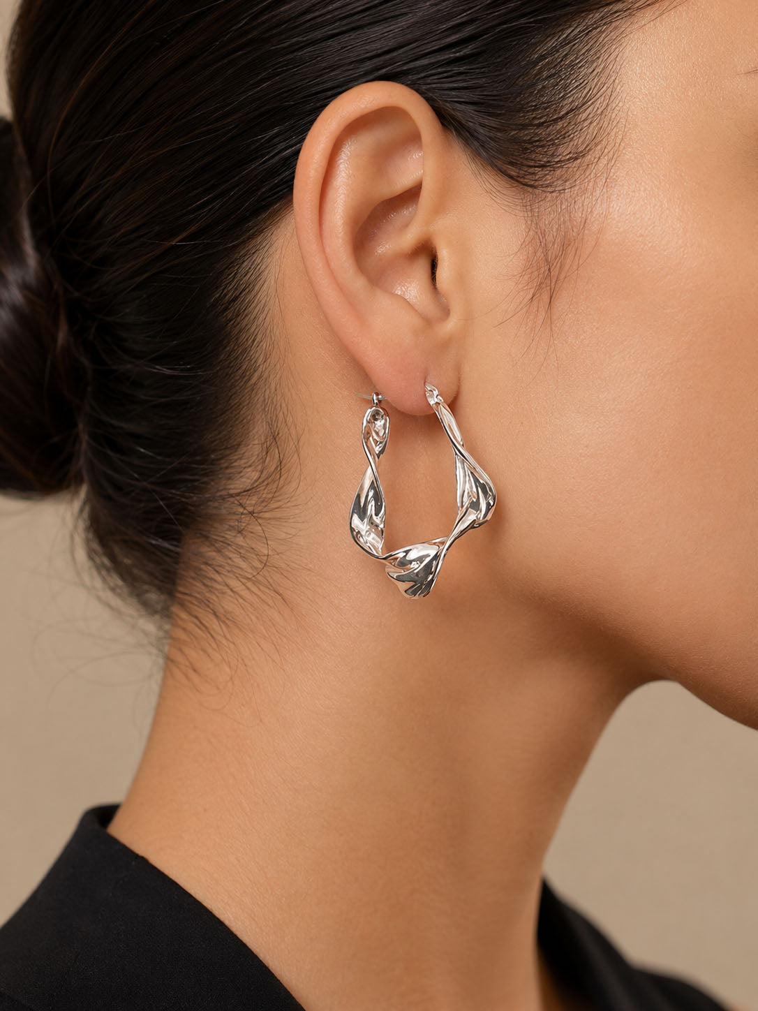 Pair of silver hoop earrings on a light gray background