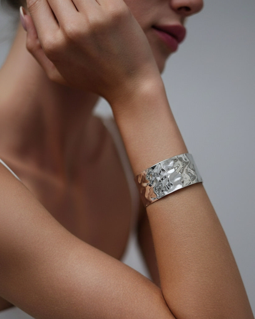 Silver-plated hammered wave cuff bracelet on model arm, modern minimalist jewelry