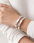 silver-plated hammered cuff bracelets worn on wrist, minimalist modern jewelry style