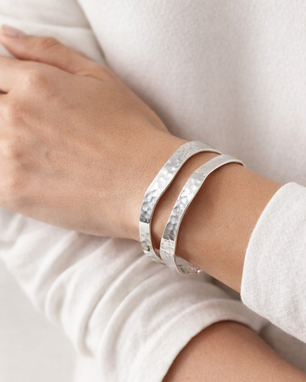 silver-plated hammered cuff bracelets worn on wrist, minimalist modern jewelry style