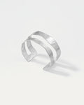 Silver cuff bracelet on a light gray background