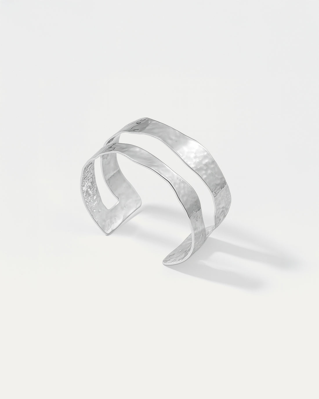 Silver cuff bracelet on a light gray background
