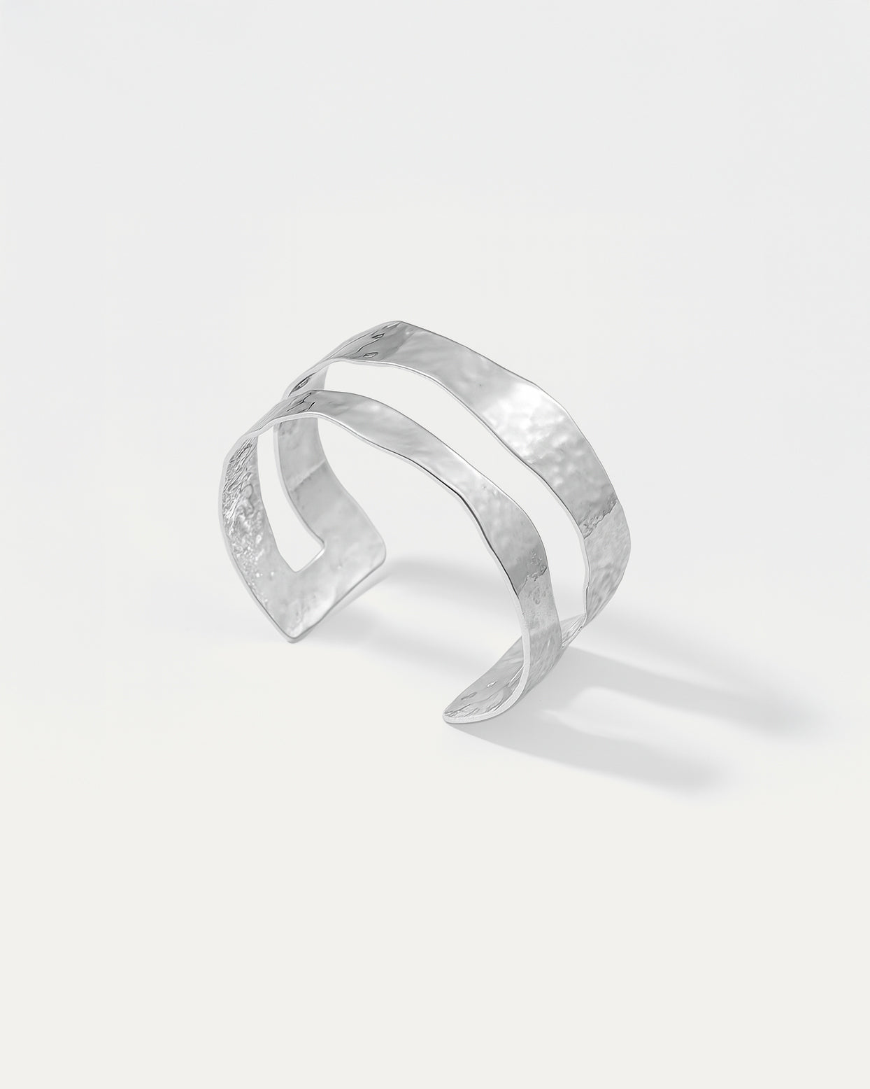 Silver cuff bracelet on a light gray background