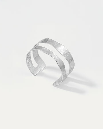 Silver cuff bracelet on a light gray background
